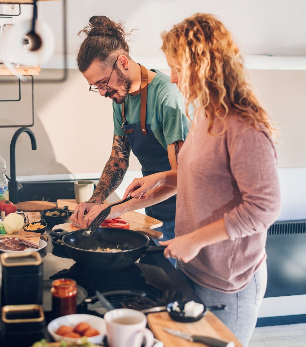 Zwei Menschen kochen gemeinsam in einer hellen Küche